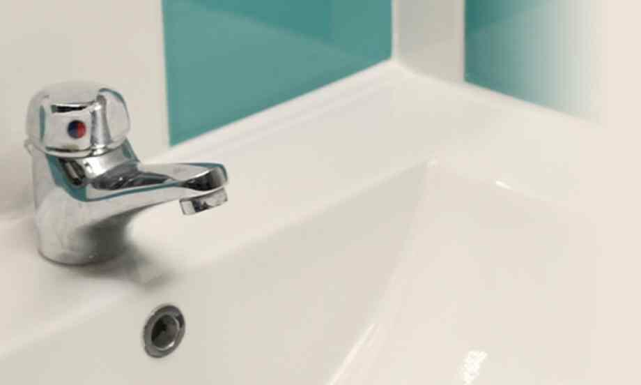 Weiße Waschbecken‑Ecke mit Armatur und offenem Fugenbereich vor türkisfarbener Fliese, ideal vorbereitet für frische, wasserfeste Silikonabdichtung im Bad.