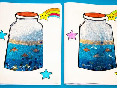 A pair of completed ocean-themed notebooks with colourful jars, glittery blue water, and cheerful rainbow stars on the cover.