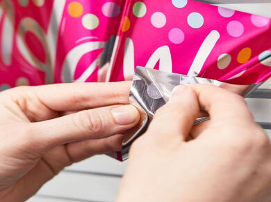 Attaching a pink polka-dot party banner using a clear removable Glu Dot