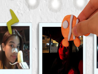 A hand holds an orange fish-shaped Blu Tack decoration next to an instant photo, ready to use it as a fun clip.