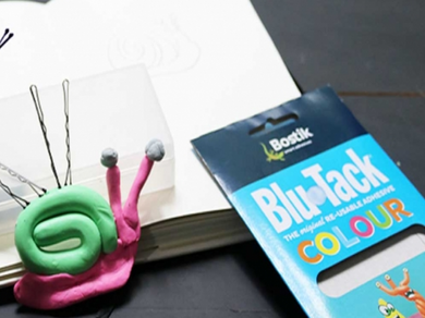 Colourful Blu Tack snail sculpture being made step by step with a notebook sketch in the background.