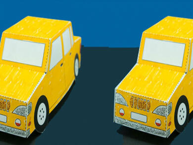 A bright yellow paper car craft made from folded cardboard, placed on a dark background, made using Bostik glue.