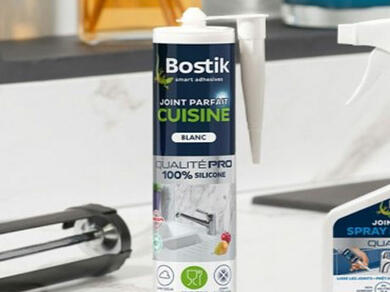 Kartuše Bostik Joint Parfait Cuisine s bílým silikonem na mramorové lince, ideální pro utěsnění spár v kuchyni.