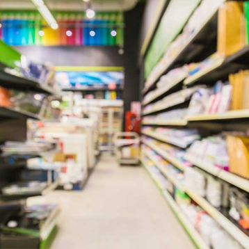 Interiér prodejny s barevnými regály plnými stavebních a DIY produktů, připravených k zakoupení pro domácí projekty.