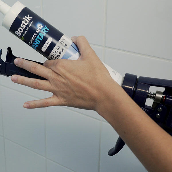 Bostik Sanitär‑Dichtstoff wird in die Kartuschenpistole eingesetzt, vorbereitet für ein präzises Auftragen neuer Silikonfugen rund um das Waschbecken.