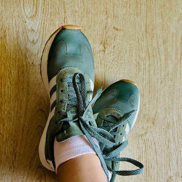 Wearing the fully repaired sneakers, ready for use again.
