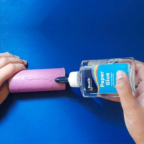 Applying Bostik Paper Glue to a painted cardboard tube during a craft project