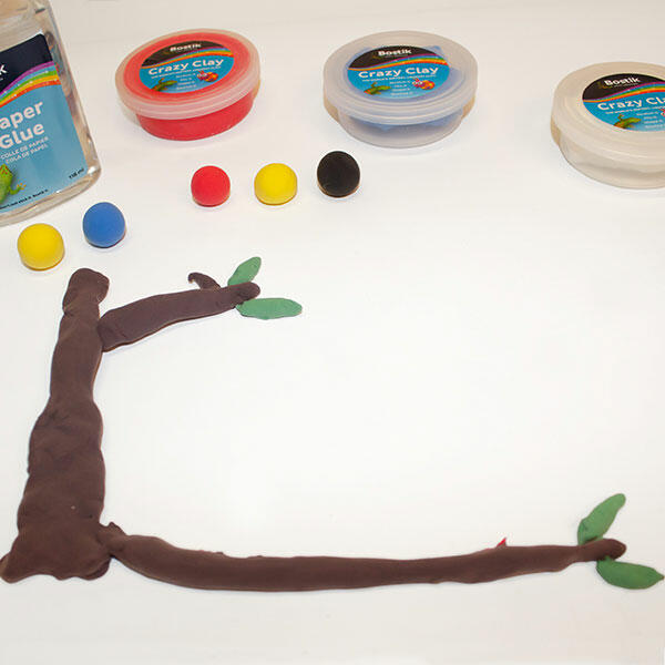 Brown clay branches and green leaves are shaped and placed on the card to create the tree background.