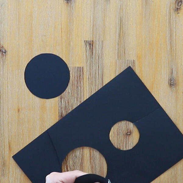 A black paper body for the ladybug is assembled by gluing two circles together, one for the head and one for the body.