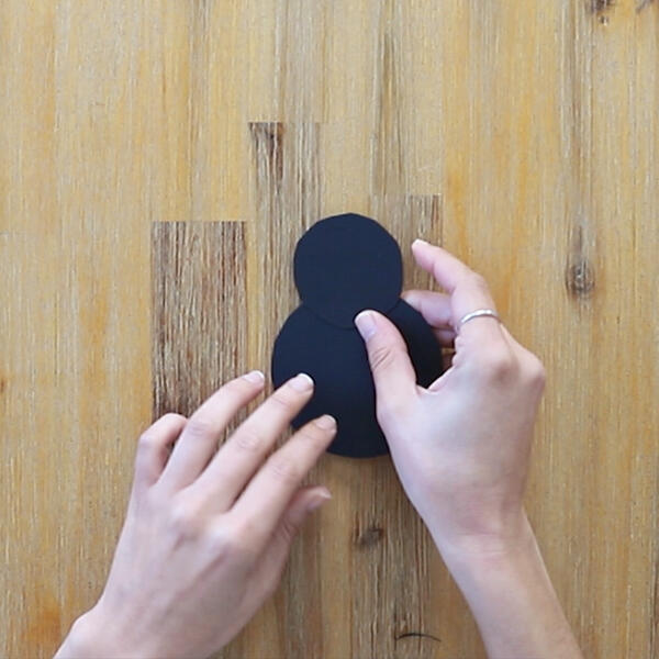 A black circle and a smaller black circle are cut from cardstock to form the ladybug's body and head.