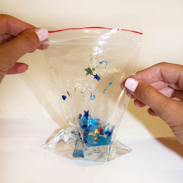 Adding glitter, stars, and sequins into the glue-filled bag for a shimmering underwater effect