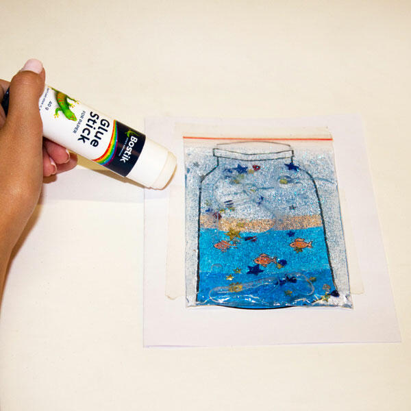 Applying Bostik Glue Stick to secure the glittery bag onto the base sheet, locking in the sparkle!