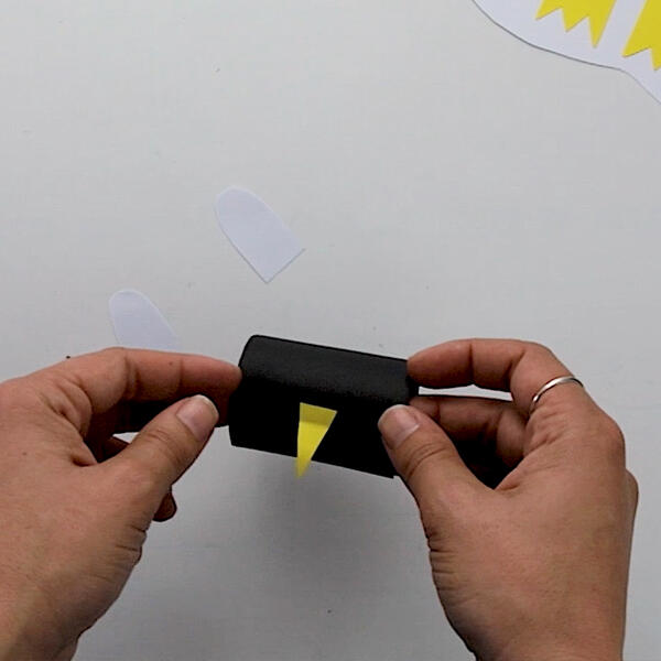 Sticking a yellow beak onto the centre of the penguin’s face to bring it to life.