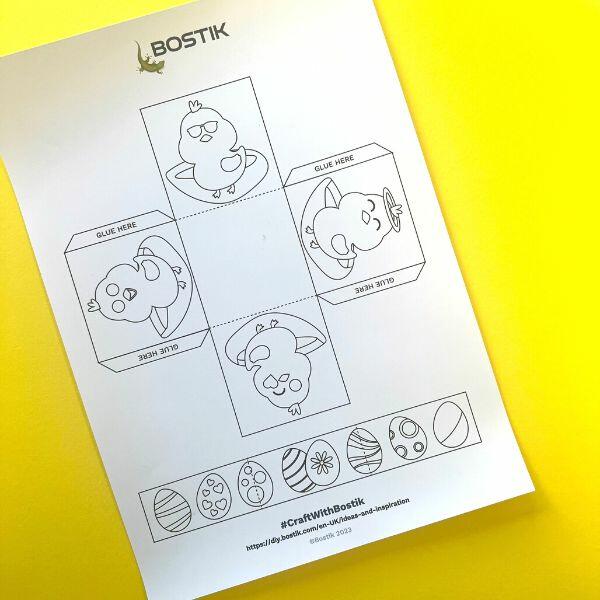 Printed Easter basket template from Bostik featuring outlined chicks and Easter eggs, ready to be coloured and cut out.