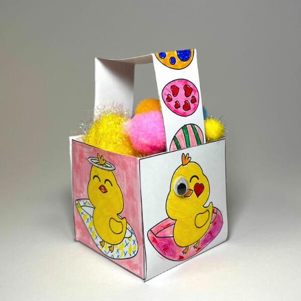 Completed Easter basket decorated with colourful chicks and eggs, filled with pom-poms.