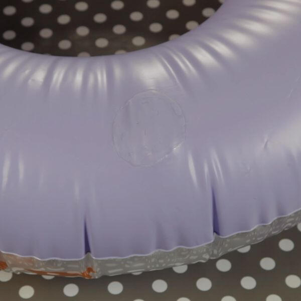 Close-up of a purple inflatable ring showing a clear glued patch repair.