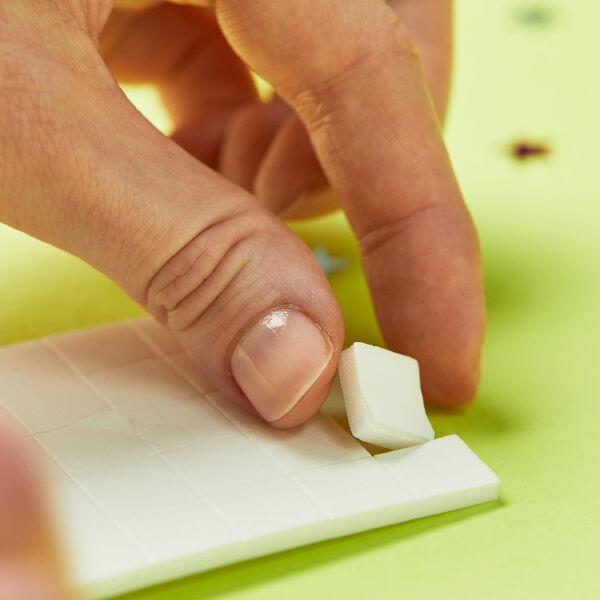 Peeling a single Bostik Foam Pad off the sheet for crafting.