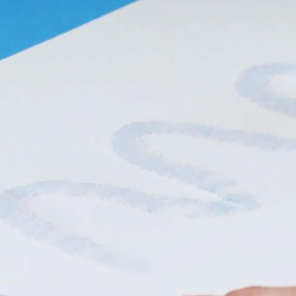 White paper with visible light-blue glue marks forming curved letters using Bostik Blu Stik adhesive.