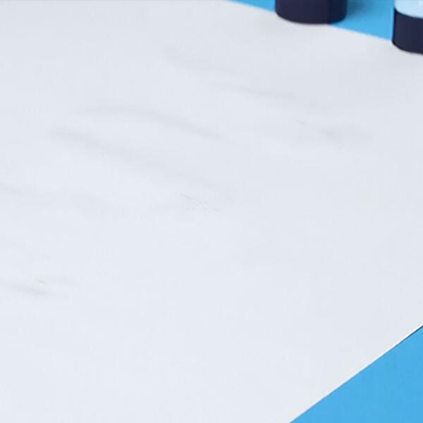 Close-up of a Bostik Blu Stik gliding across white paper, leaving a visible blue adhesive line that will dry clear.