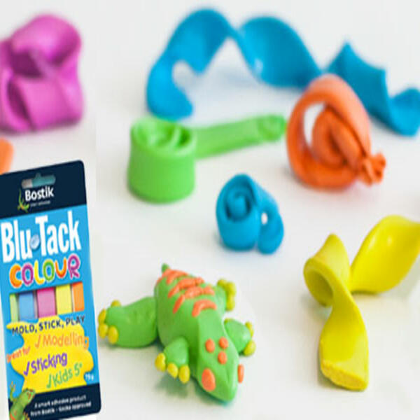 A lump of green Blu Tack is shaped into the gecko’s body with small orange and yellow pieces ready for decoration.