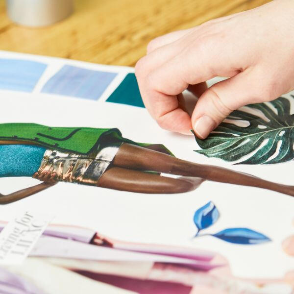 Hand lifting a cut-out leaf image from a collage, showing repositioning made possible with spray adhesive