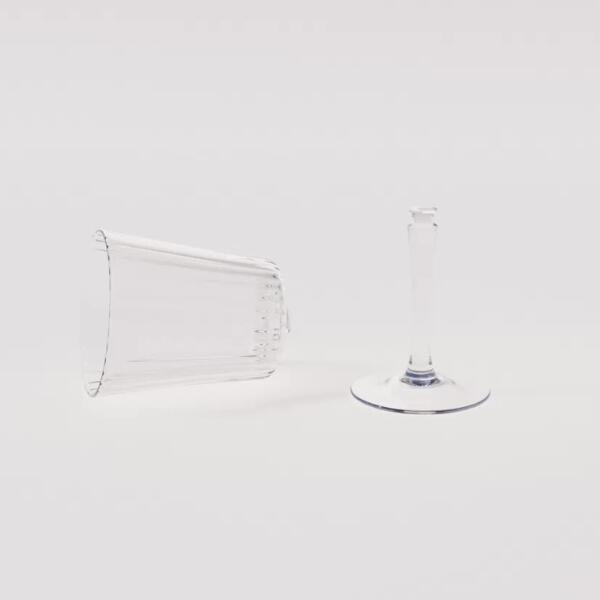 Broken crystal wine glass separated at the stem and bowl, placed on a white background